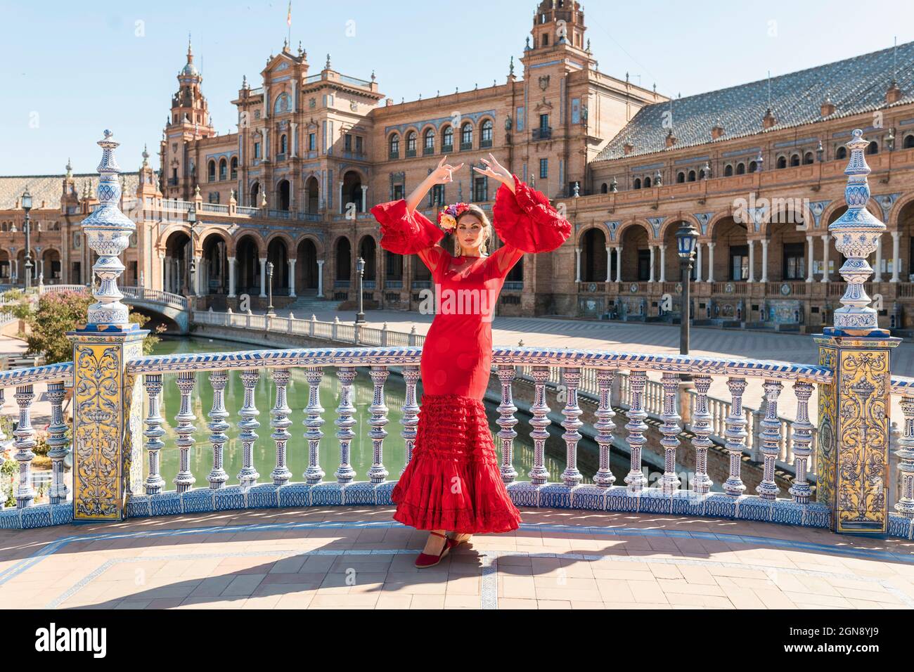 Artista flamenco femminile che balla con le mani alzate a Plaza De Espana a Siviglia, in Spagna, nella giornata di sole Foto Stock