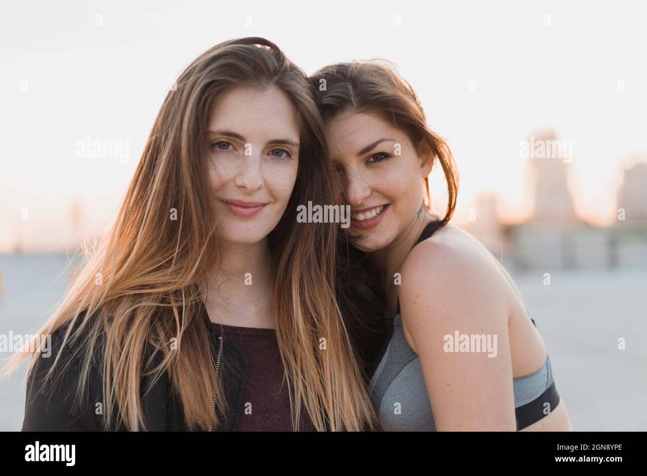 Donna sorridente appoggiata su un'amica Foto Stock