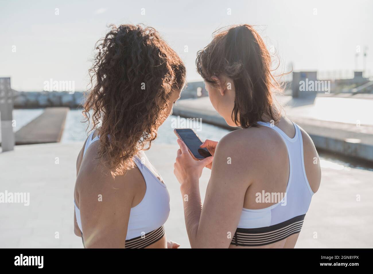 Donne in abbigliamento sportivo con smartphone Foto Stock