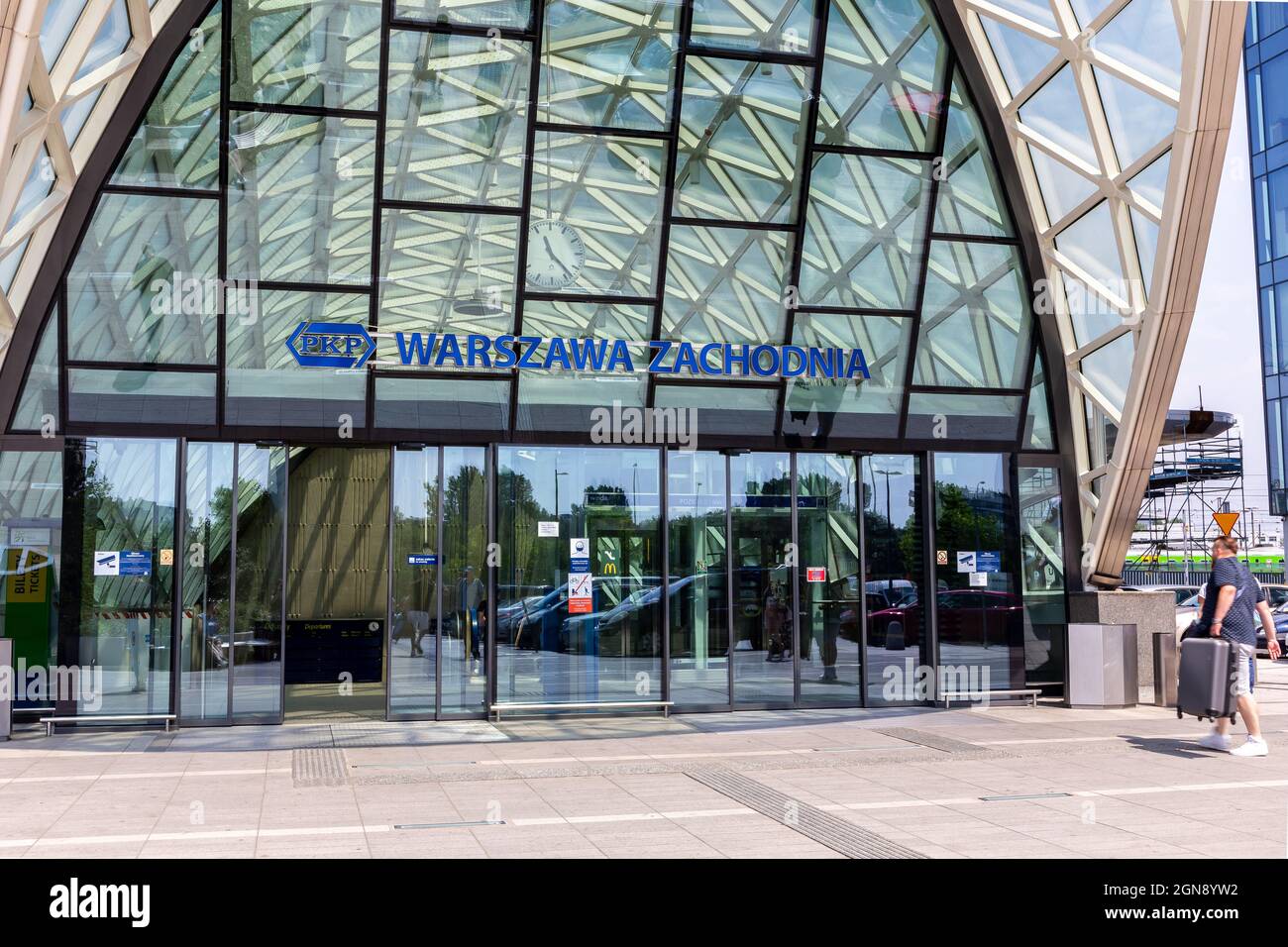 Varsavia, Polonia, 09.07.2021. PKP Warszawa Zachodnia, Warsaw West stazione dei treni e degli autobus nuovo edificio moderno in vetro con i passeggeri che entrano nella stazione. Foto Stock