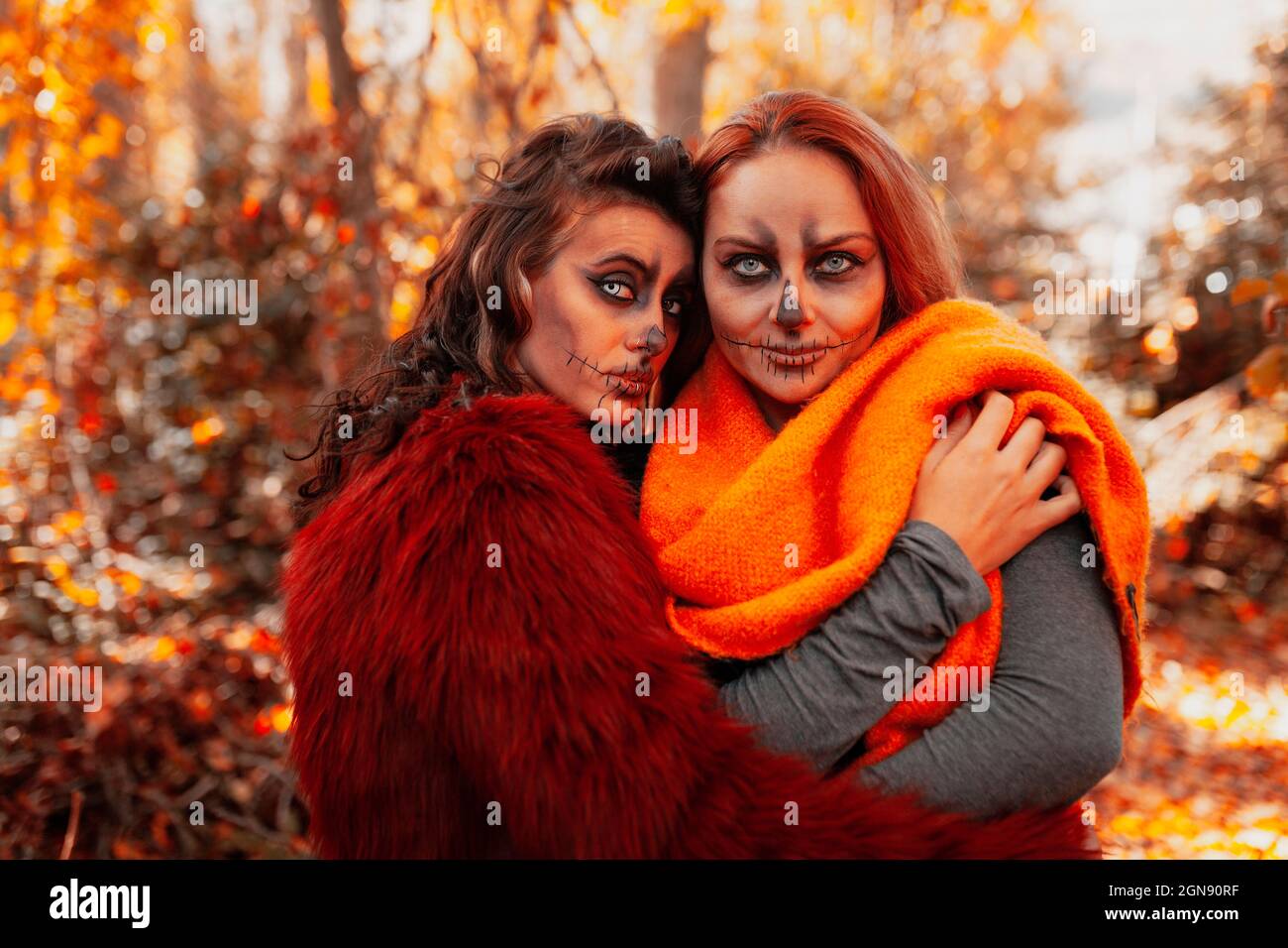 Donna con Halloween make-up hugging amico in foresta Foto Stock