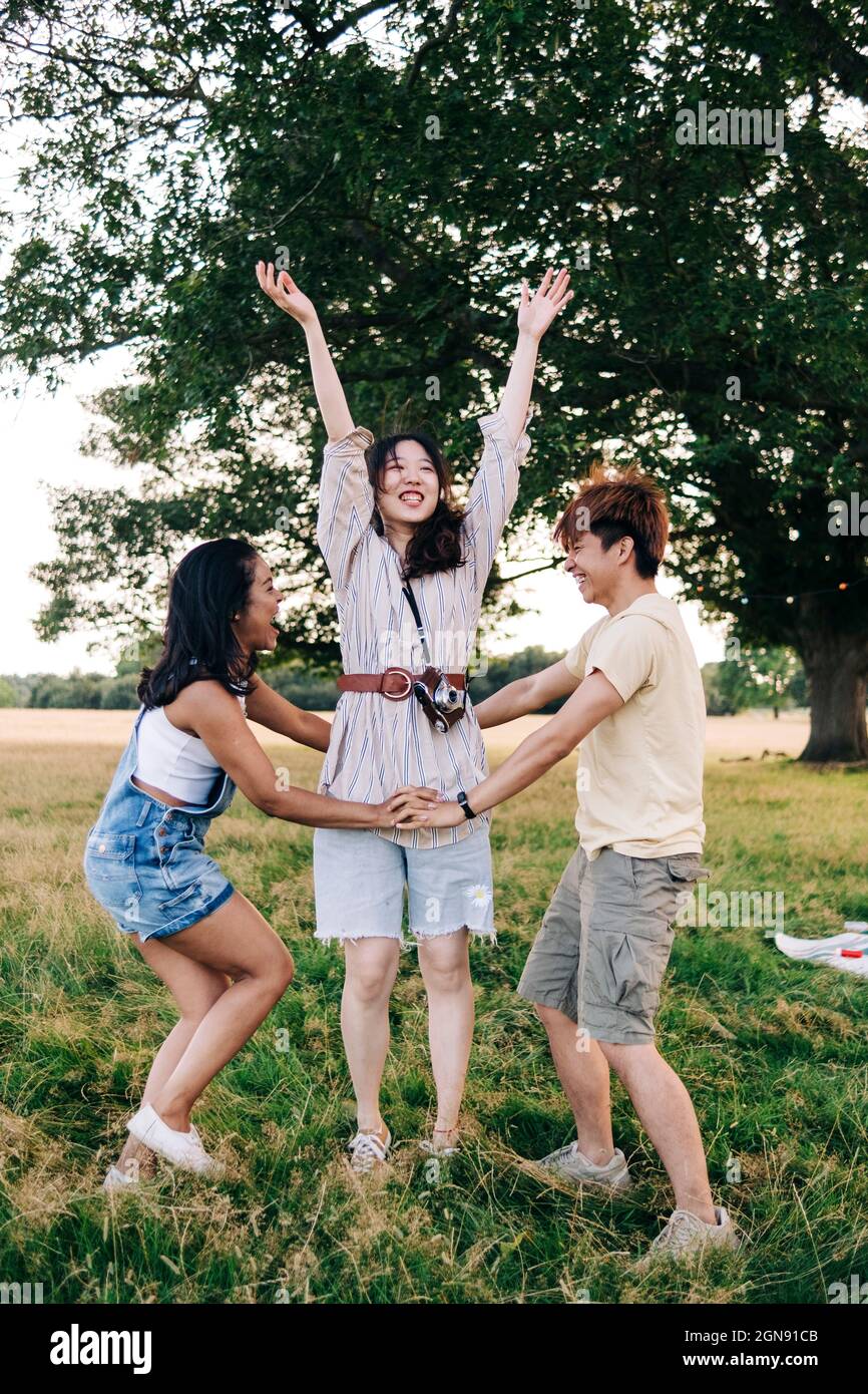 Amici allegri che giocano insieme al parco Foto Stock