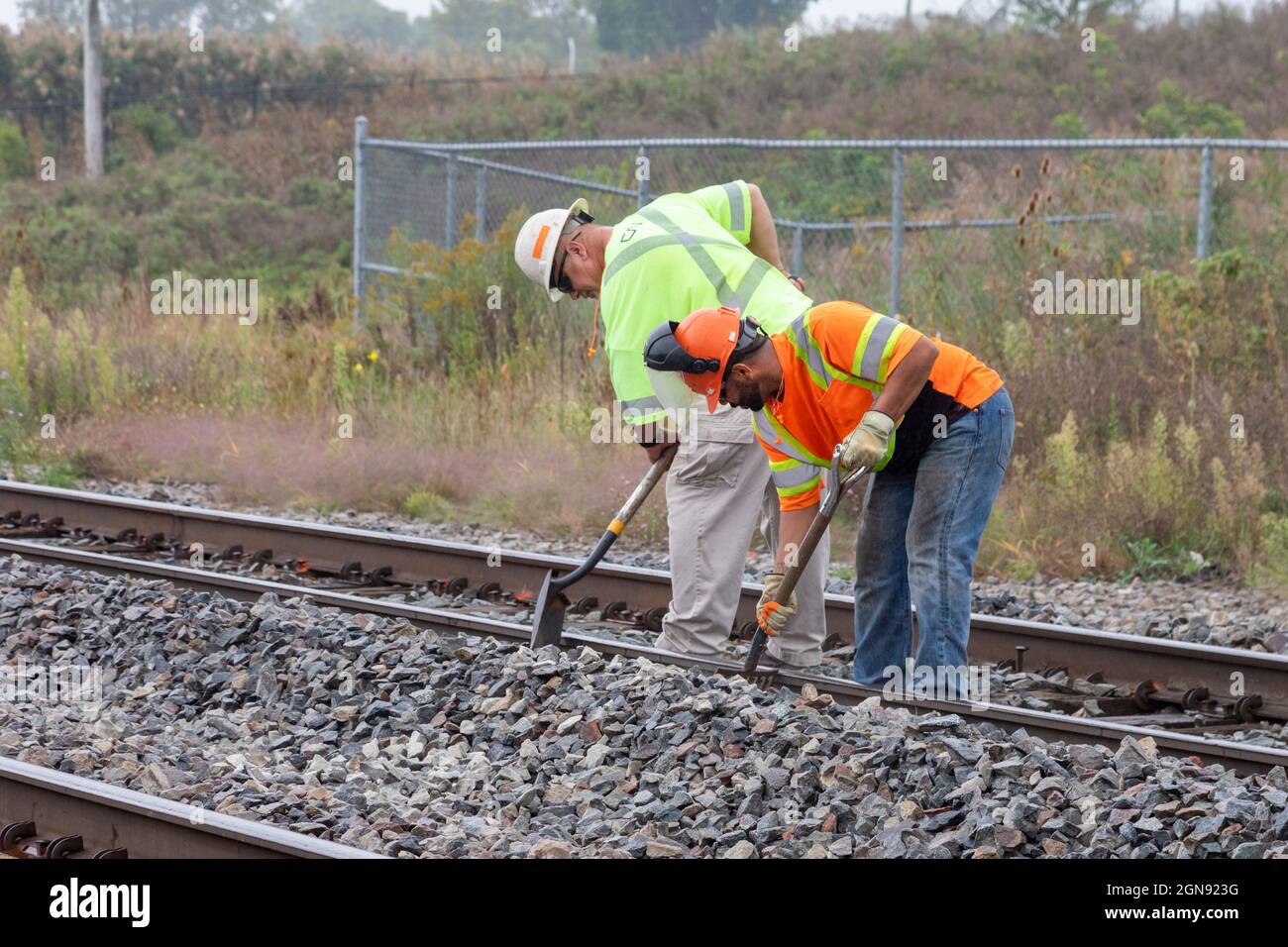 Pontiac, Michigan - Un equipaggio di manutenzione ferroviaria lavora sui binari della CN Railroad, pulendo i detriti per prepararsi alle riparazioni dei binari. Foto Stock