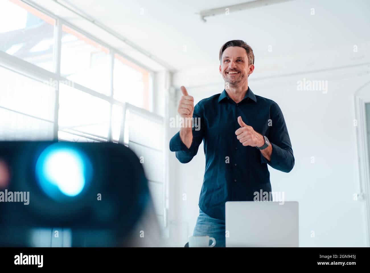 Sesso maschile maturo professionale gesturing dando la presentazione in sala riunioni Foto Stock