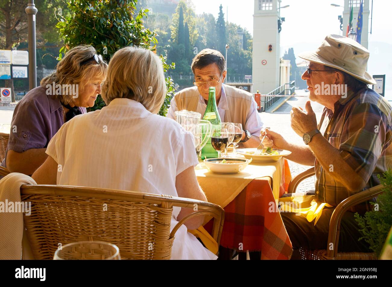 Gli amici mangiano il pranzo in un ristorante sul lago di Como, Italia Foto Stock