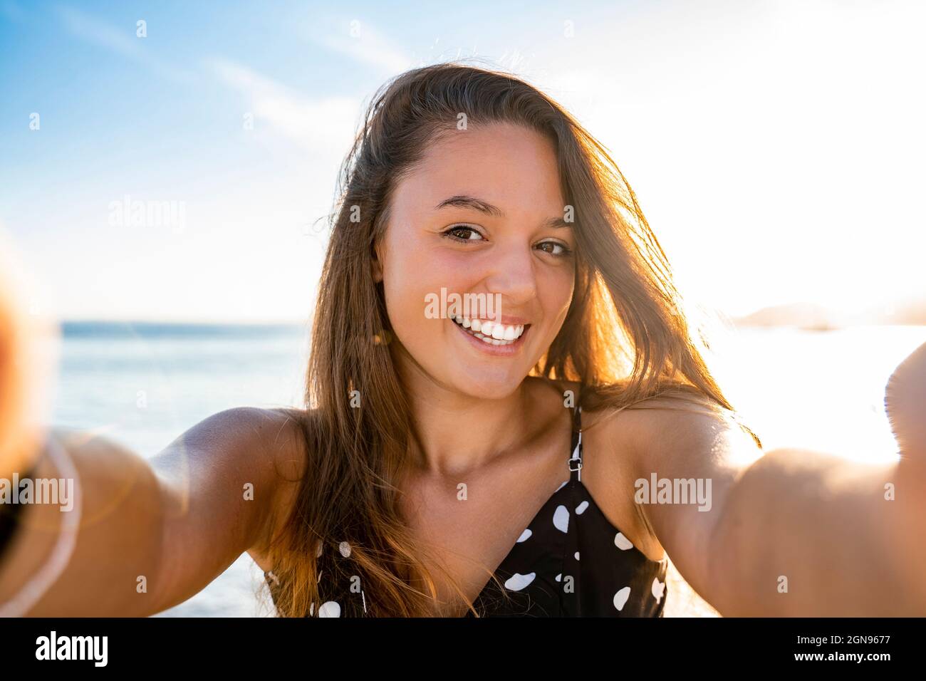 Felice bella donna che prende selfie in spiaggia Foto Stock