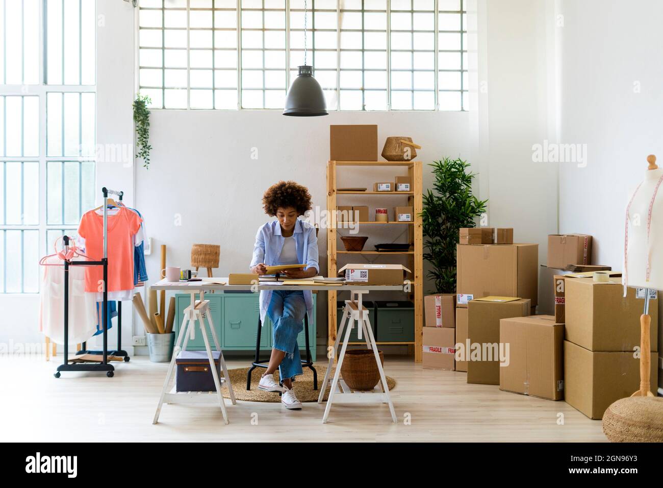 Imprenditore di moda femminile utilizzando lo smartphone in studio Foto Stock