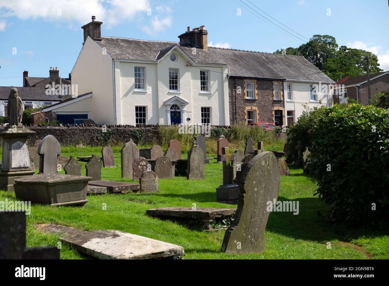 Fila di case e tombe lapidi lapidi in cimitero murato di fronte alla chiesa di St Edmund in estate Crickhowell Powys Wales UK KATHY DEWITT Foto Stock