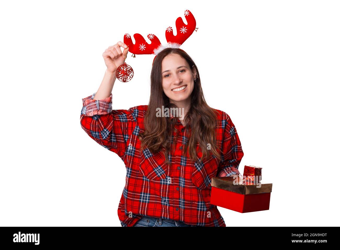 Felice giovane donna che indossa una camicia rossa a quadri sta tenendo  alcune decorazioni di Natale su sfondo bianco Foto stock - Alamy