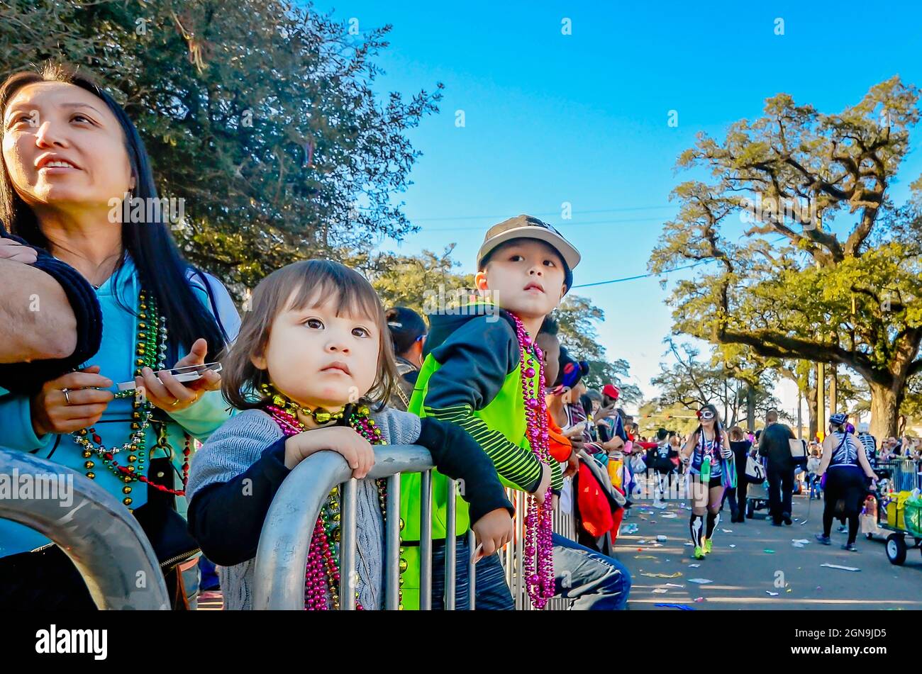 Una famiglia guarda la parata Joe Cain Day Mardi Gras, 7 febbraio 2016, a Mobile, Alabama. I coloni francesi tennero il primo Mardi Gras nel 1703. Foto Stock