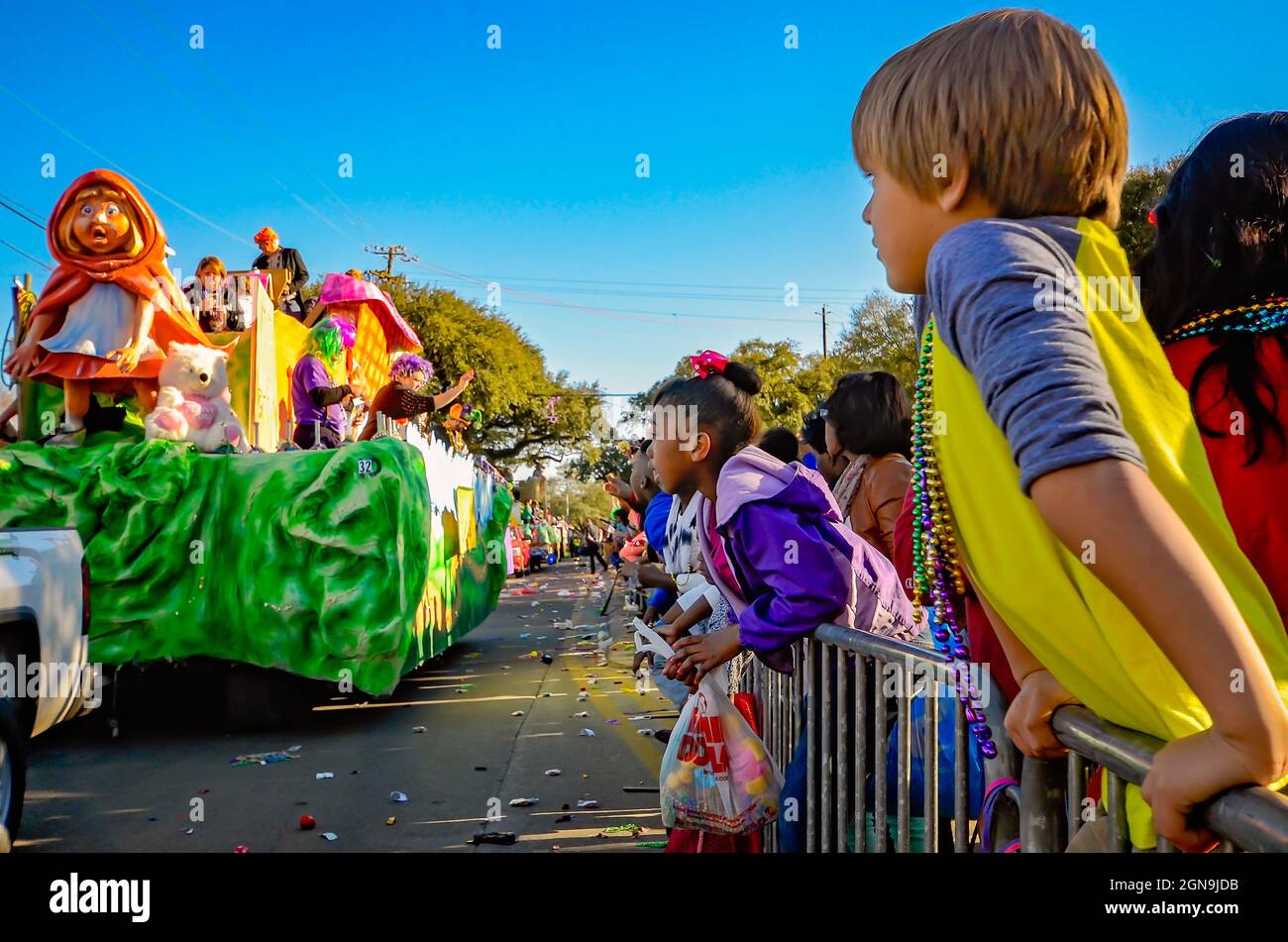 I bambini guardano un mardi Gras galleggiare con un piccolo tema Red Riding Hood durante la parata del Mardi Gras del Joe Cain Day a Mobile, Alabama. Foto Stock