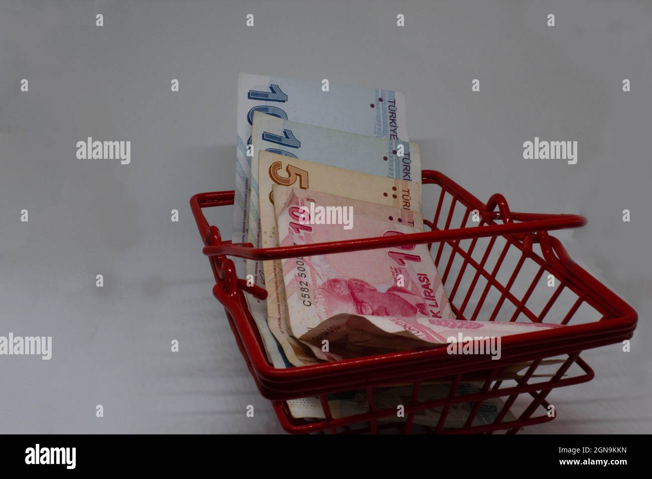 Lire turche in un cestino rosso, piccolo shopping. Dicendo che la lira turca ha quasi zero potere d'acquisto. Basso potere di soldi. Cattiva economia della Turchia. Foto Stock