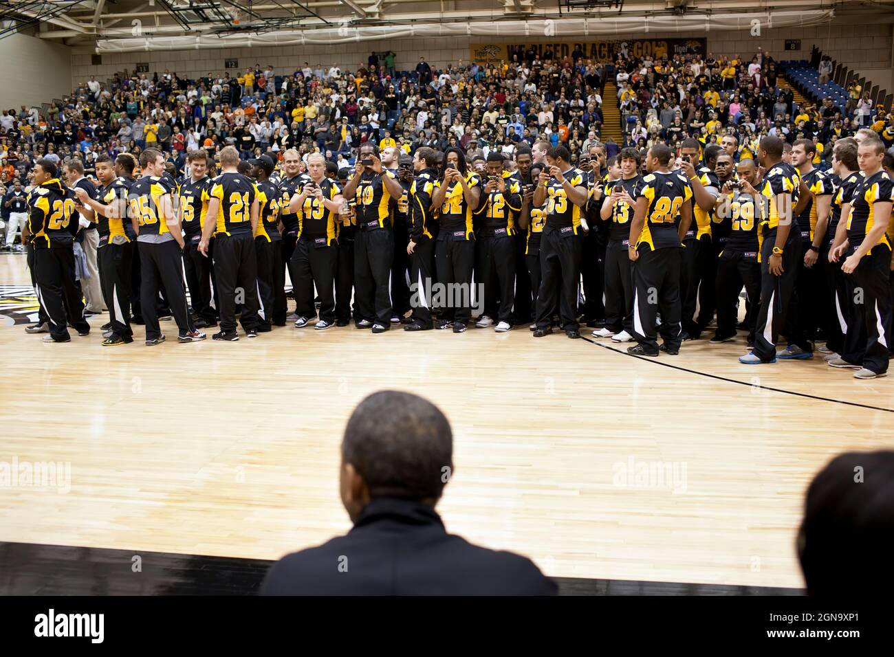 I membri della squadra di football della Townson University scattano foto del presidente Barack Obama durante la metà della partita di basket Oregon state vs Towson University a Towson, Md., 26 novembre 2011. I membri della squadra di calcio sono stati onorati per aver vinto il titolo della stagione regolare della Colonial Athletic Association. (Foto ufficiale della Casa Bianca di Pete Souza) Foto Stock