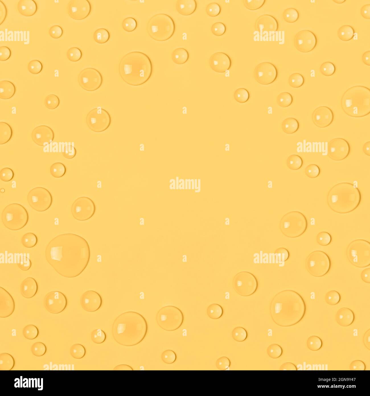 Cornice di gocce d'acqua su sfondo giallo pastello. Acqua texture close up. Sfondo vetro coperto da gocce d'acqua. Bolle d'acqua. Foto Stock
