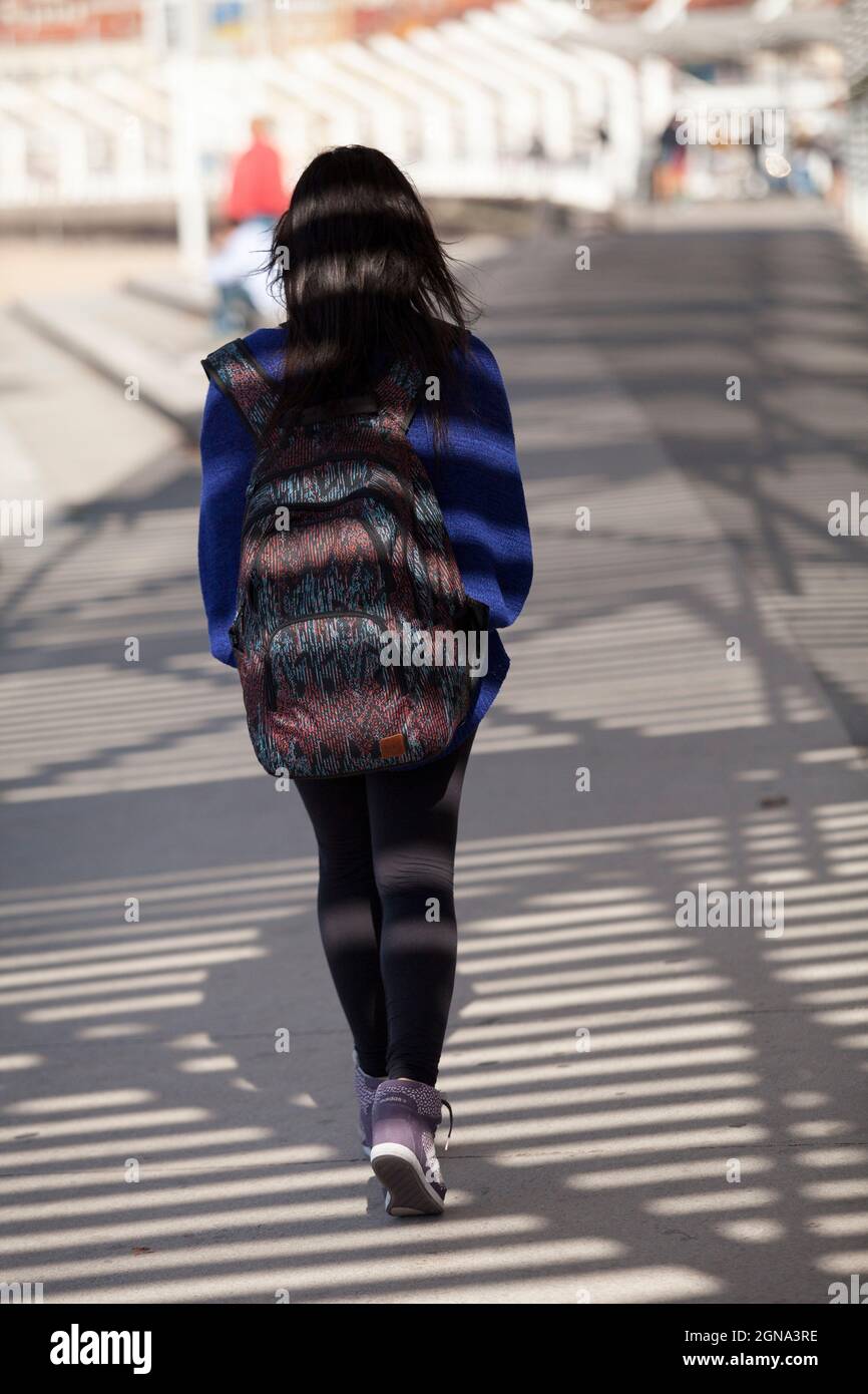Turista femminile che cammina su un lungomare di gijon spagna, Foto Stock