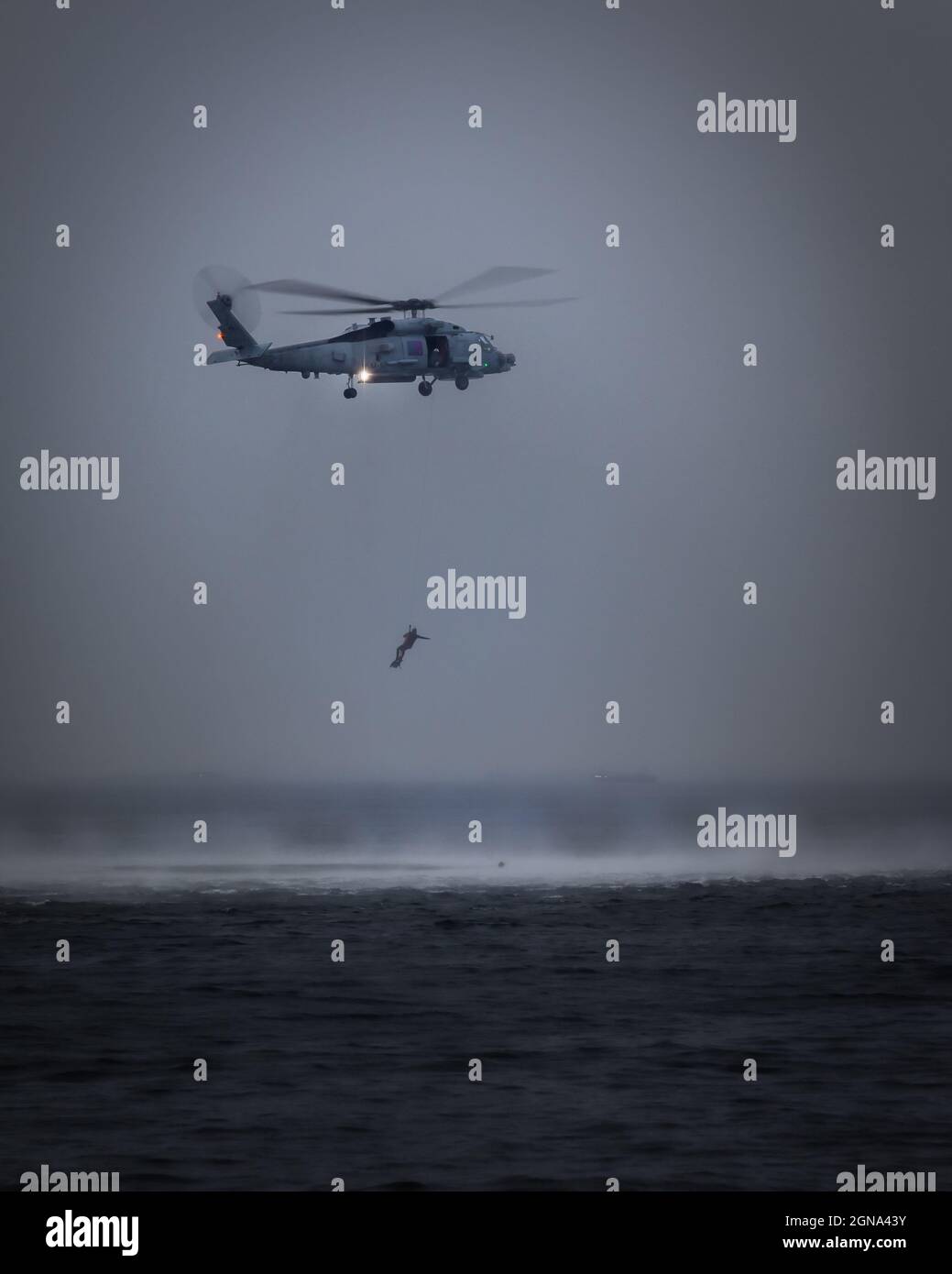 Un addestramento dell'elicottero della Marina degli Stati Uniti MH-60 con i nuotatori di salvataggio nella Baia di Tokyo vicino a Yokosuka, Giappone. Foto Stock