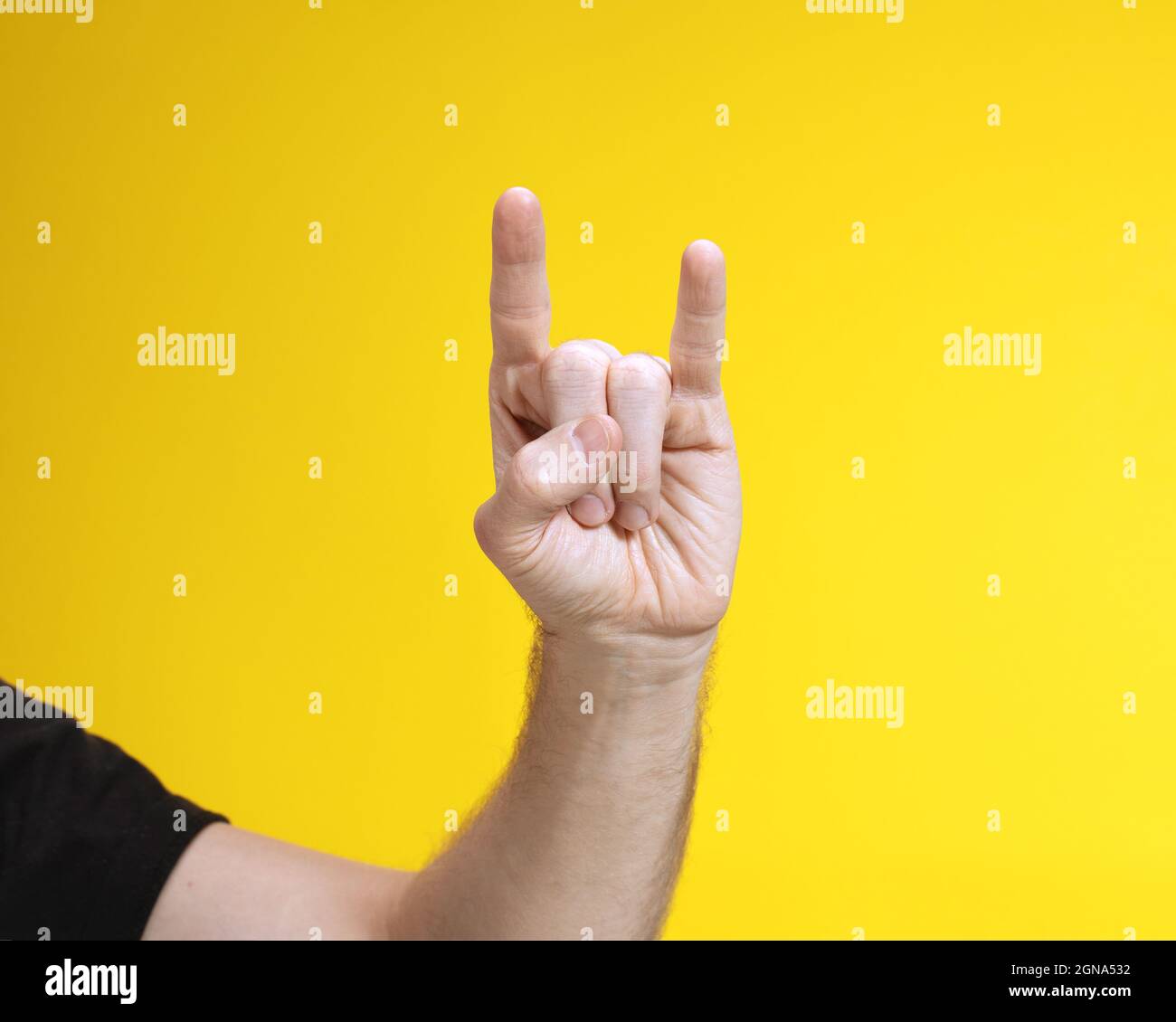 Mano dell'uomo su sfondo giallo che mostra due dita che significano freddo. Gesto popolare della gioventù. Foto Stock