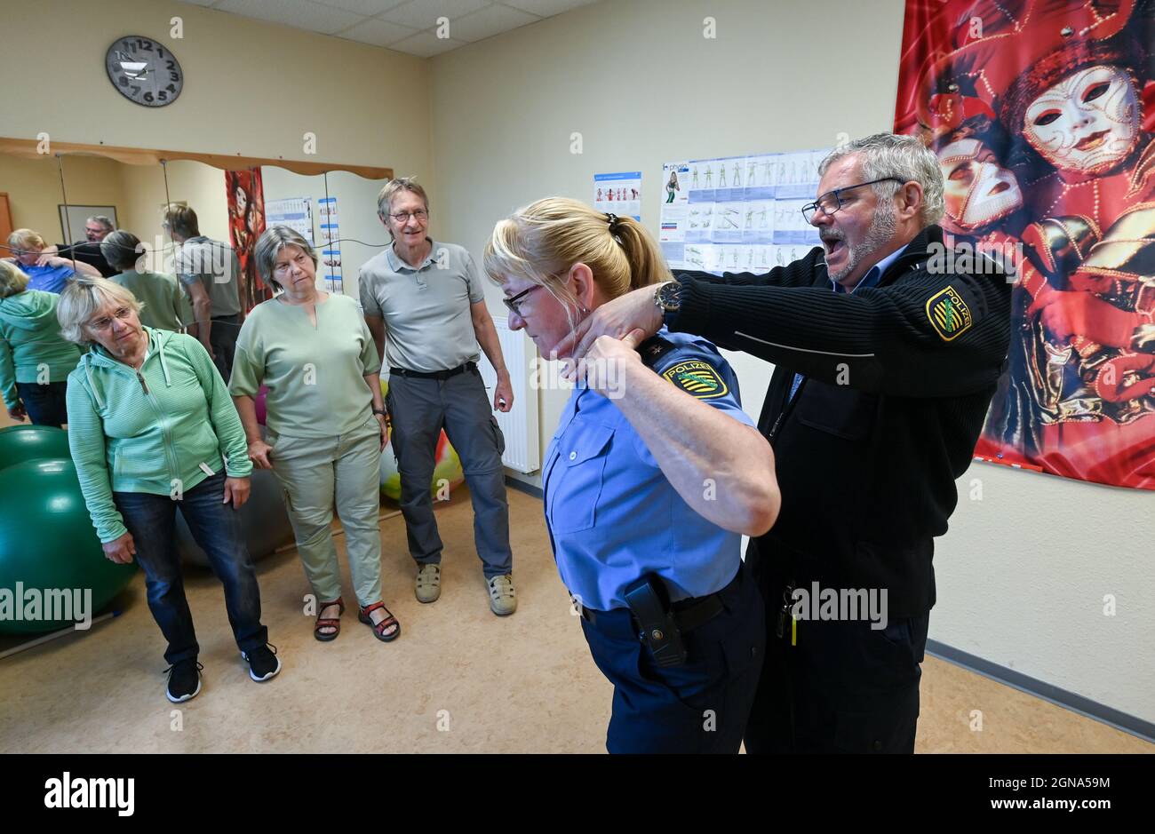 23 settembre 2021, Sassonia, Lipsia: I funzionari di polizia Stephan Weinhold (r) e Ramona Mertens (2° da destra) dimostrano ai partecipanti a un corso di assertività per gli anziani di Lipsia come liberarsi da una stanghetta. In otto unità, i partecipanti imparano ad agire con sicurezza nella vita quotidiana e a difendersi da delitti o crimini violenti. I corsi hanno avuto luogo dal 2008 - la polizia ha dovuto fare una pausa a causa della pandemia di Corona. Sono costituiti da parti teoriche e pratiche. In teoria, i partecipanti discutono con gli ufficiali come Foto Stock