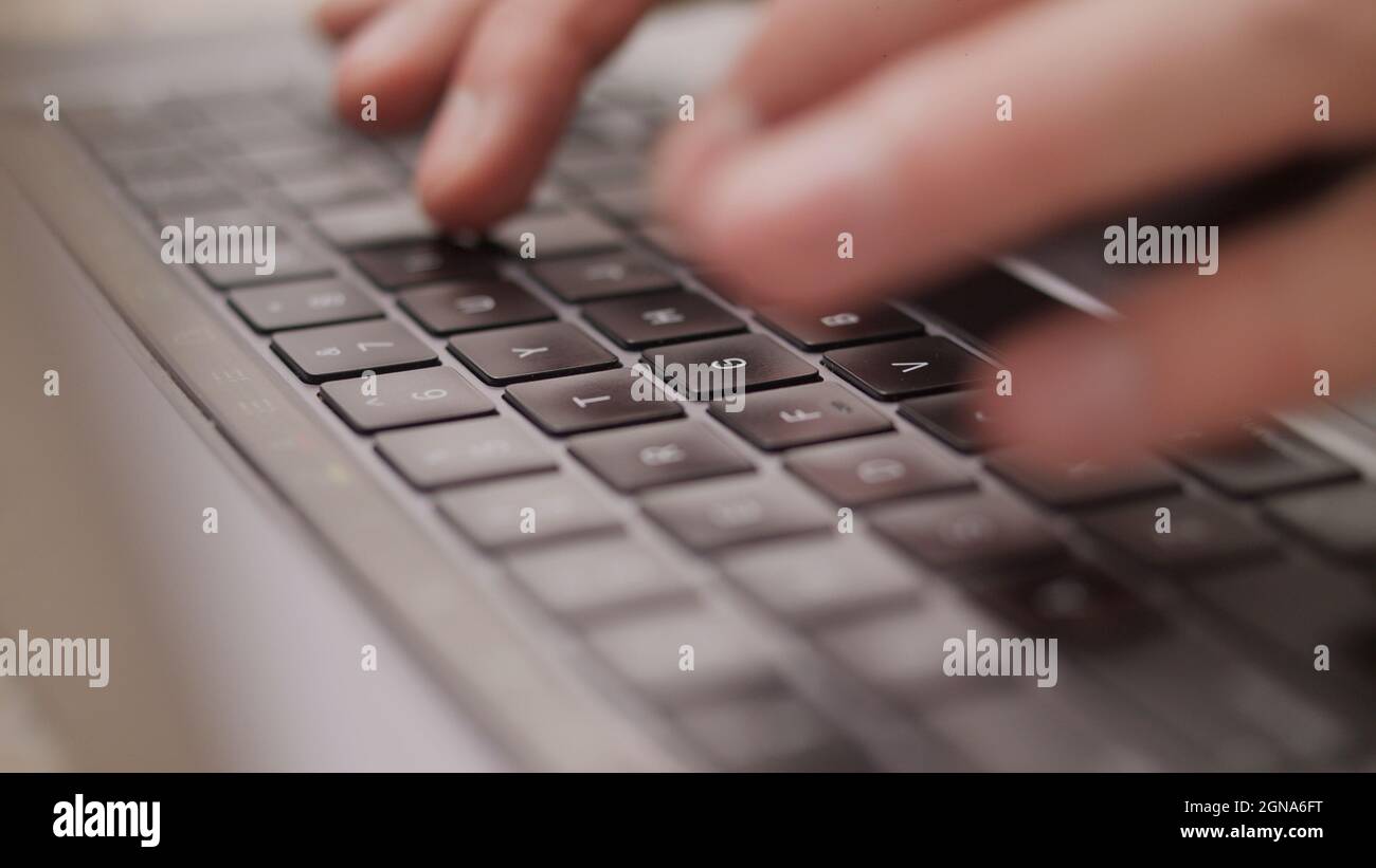 Primo piano macro delle mani digitando sulla tastiera del computer portatile mac Foto Stock