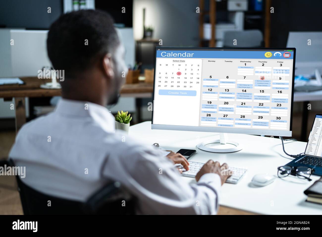 Pianificazione del calendario di fare afroamericano. Agenda aziendale in ufficio Foto Stock