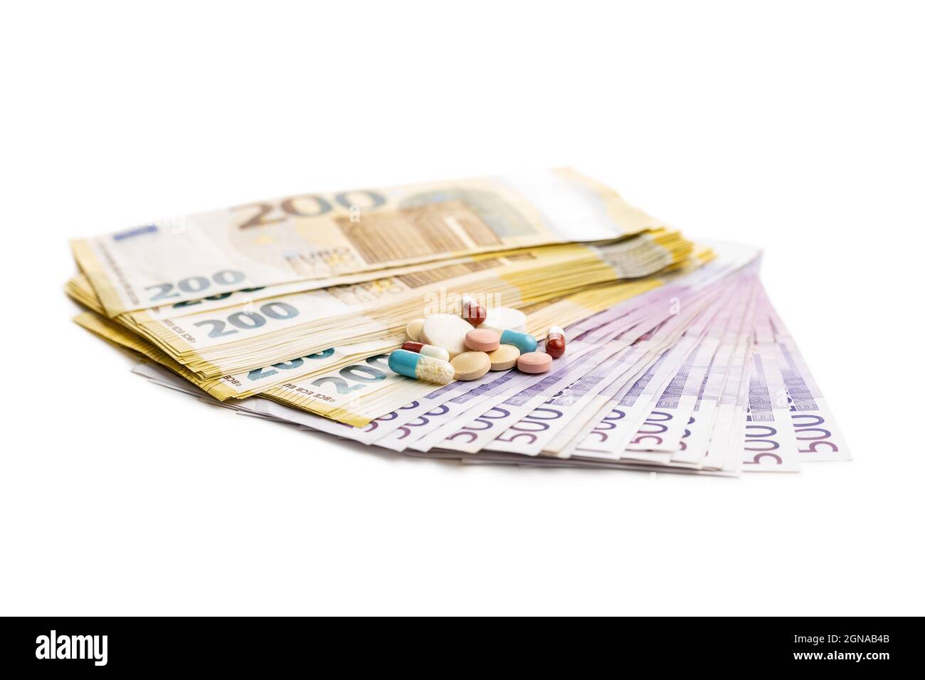 Banconote e pillole in euro isolate su sfondo bianco. Foto Stock