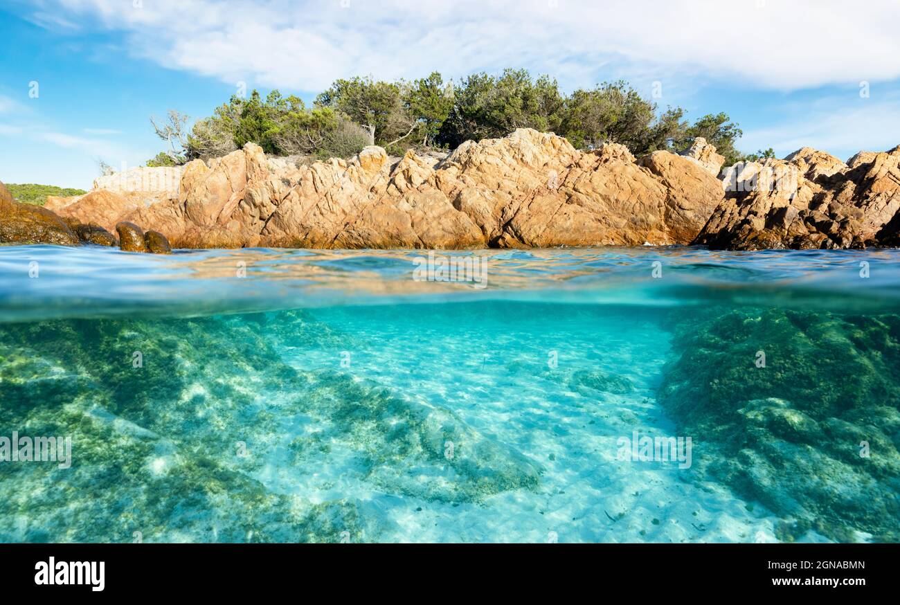 Scatto diviso, sopra sotto la foto. Metà sott'acqua con acque turchesi e una costa rocciosa sulla superficie dell'acqua. Spiaggia del Principe (Spiaggia del Principe) Foto Stock