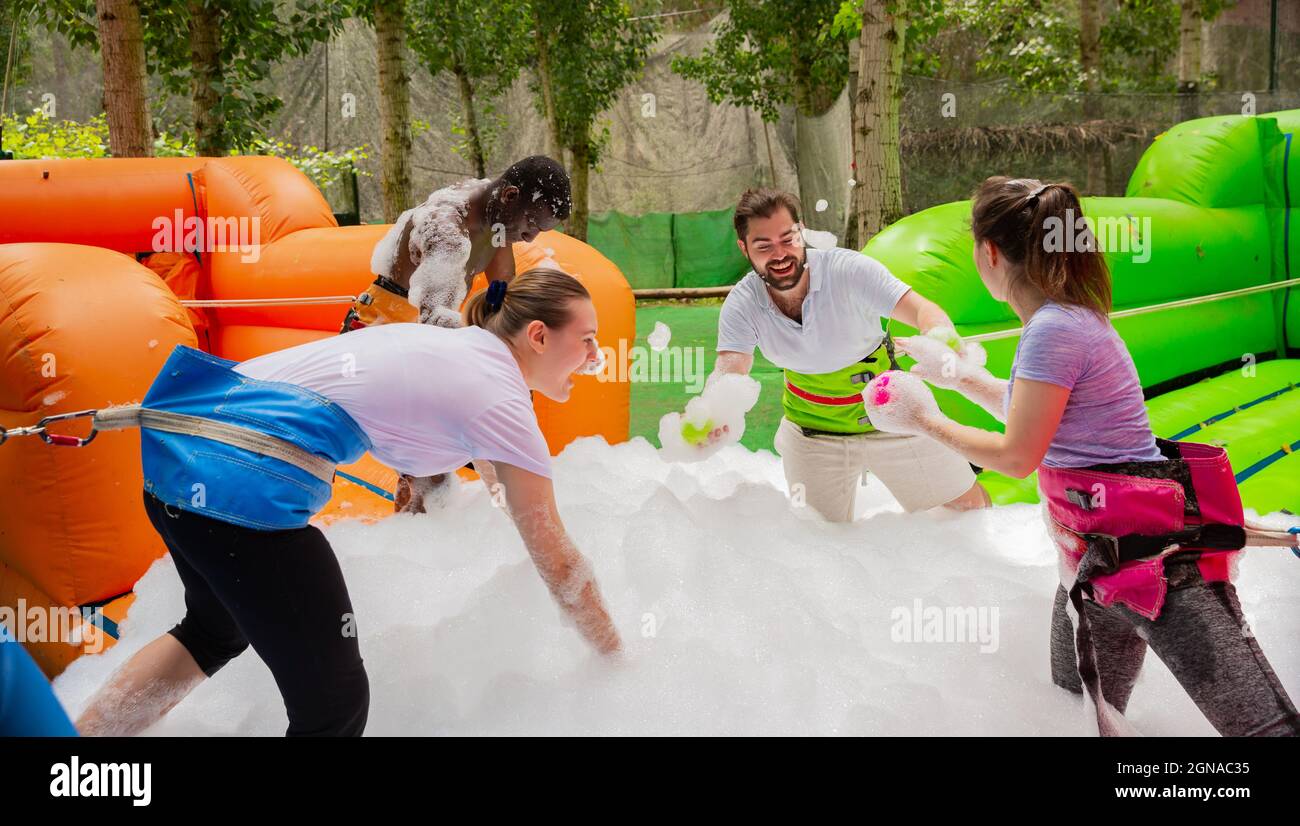 Happy amici stanno giocando a un gioco - che troveranno le palle in schiuma di sapone più veloce Foto Stock
