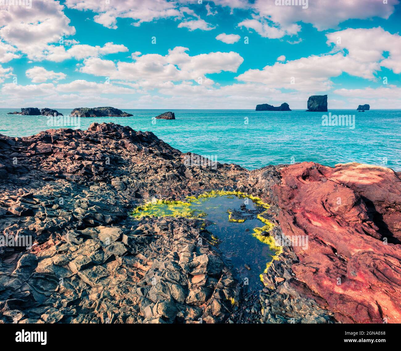 Colorata mattinata estiva nella Riserva Naturale di Dyrholaey. Grande vista dell'arco di Dyrholaey, costa meridionale dell'Islanda, Europa. Foto elaborata in stile artistico Foto Stock