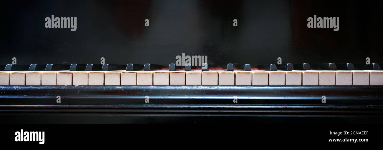 Tastiera di un vecchio pianoforte con tasti bianchi e neri di avorio ed ebano, formato panoramico con spazio di copia, messa a fuoco selezionata Foto Stock