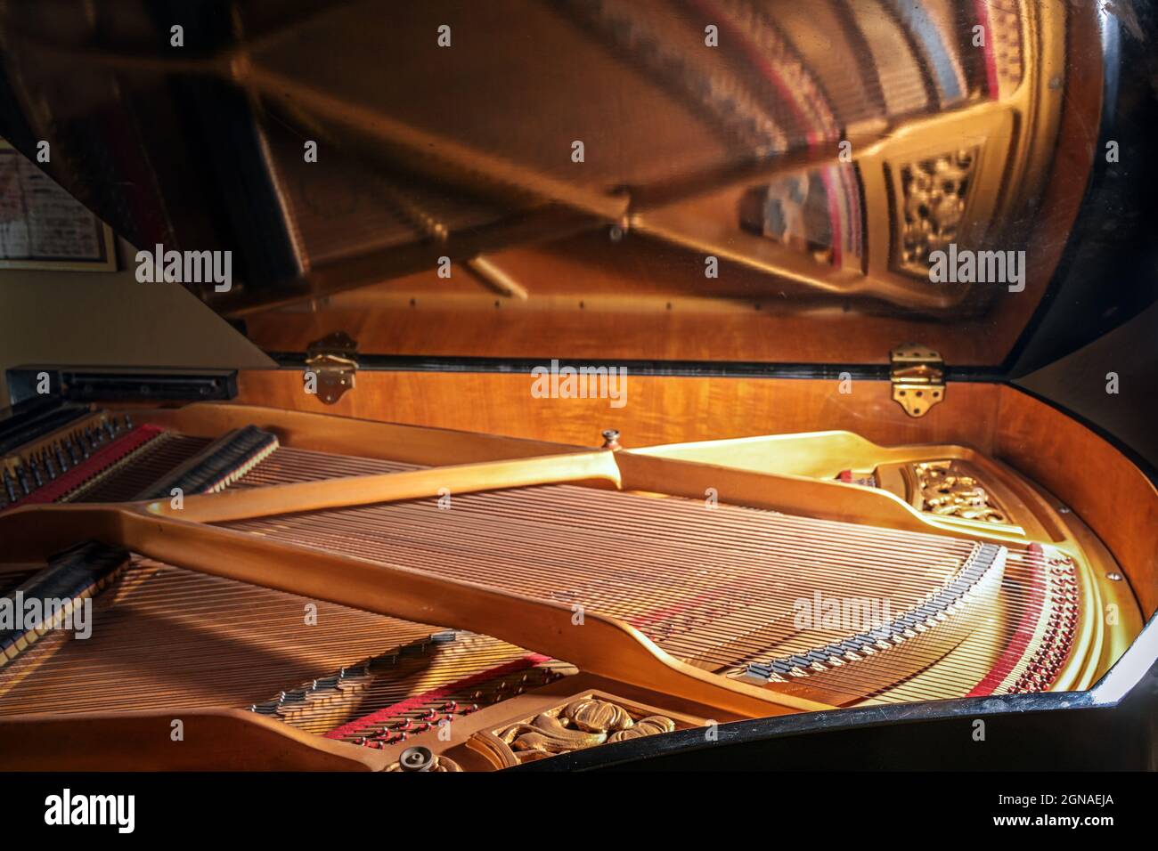 All'interno di un pianoforte con specchio di cornici e archi nel coperchio aperto dello strumento musicale, concetto per musica, arte e intrattenimento, selecte Foto Stock