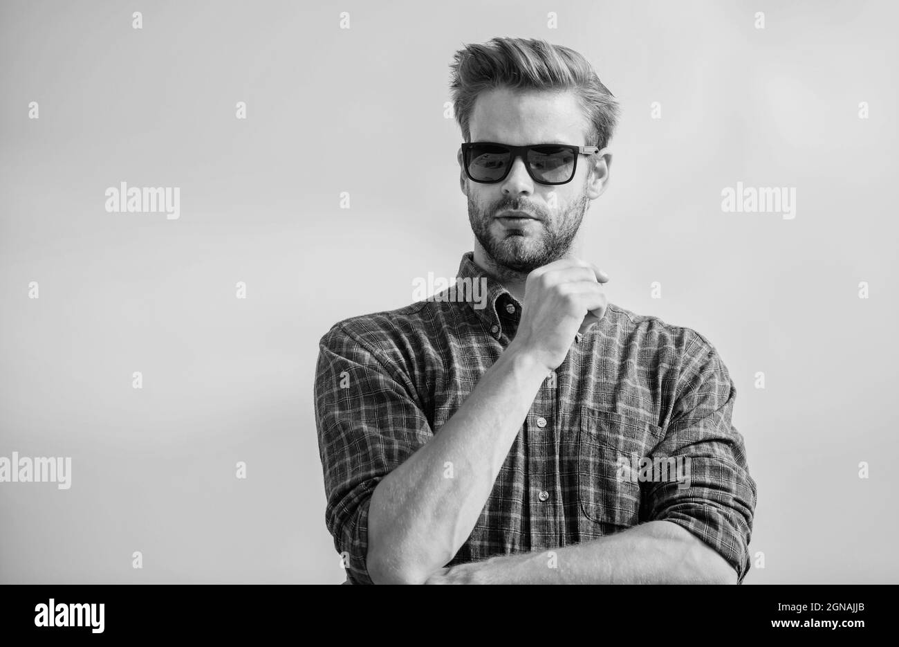 Concetto di protezione ultravioletta. Uomo modello eyewear esterno cielo blu sfondo. Visione perfetta. Vedere chiaro. Bel ragazzo indossare occhiali da sole. Hipster Foto Stock