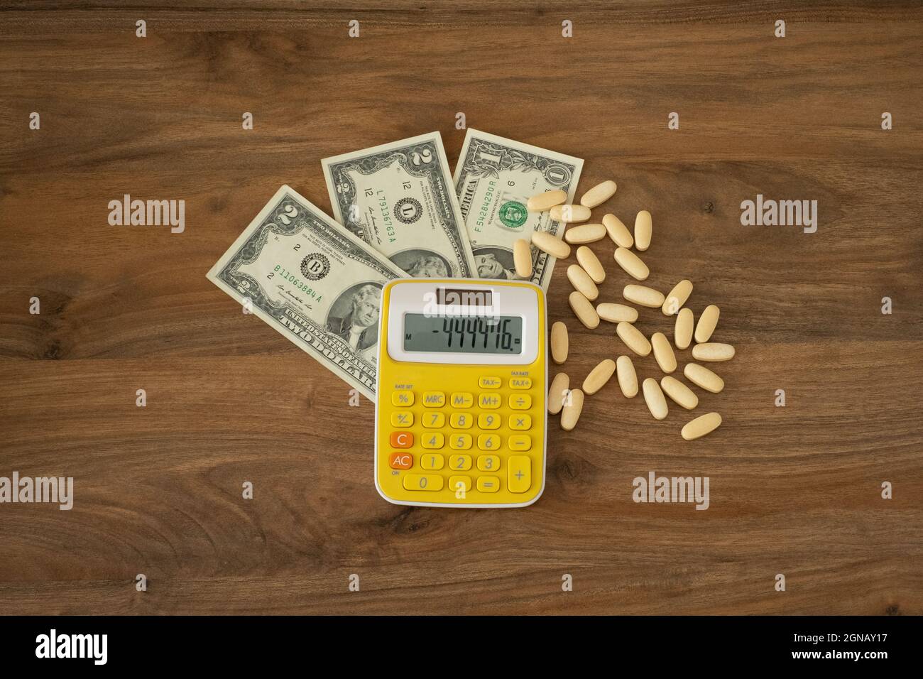 Idea del suicidio. Pillole, soldi e calcolatrice su uno sfondo di legno vista dall'alto. Medicina paid, concetto di distress idea finanziaria. Foto Stock