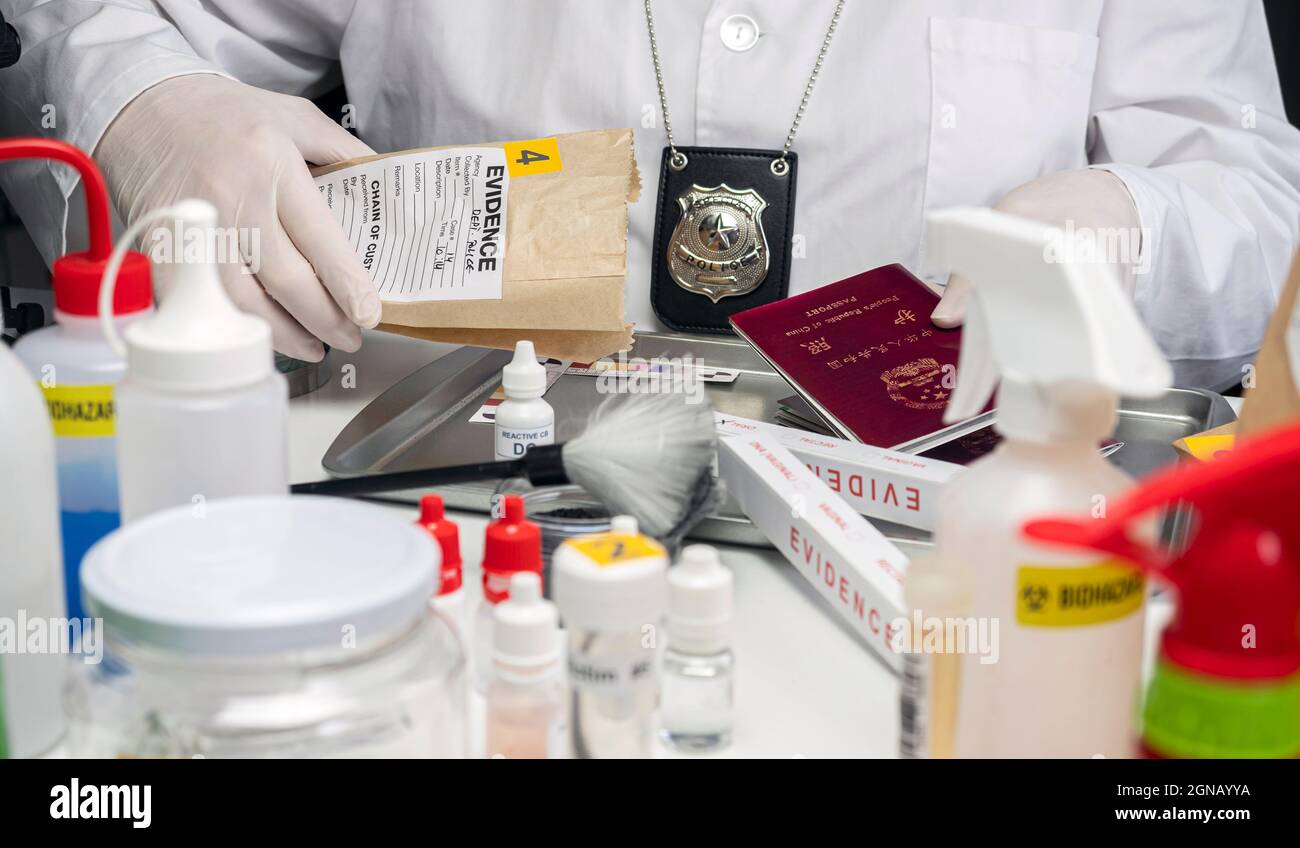 Esperto di polizia che esamina il passaporto cinese di una borsa di prove in laboratorio criminalistico, immagine concettuale Foto Stock