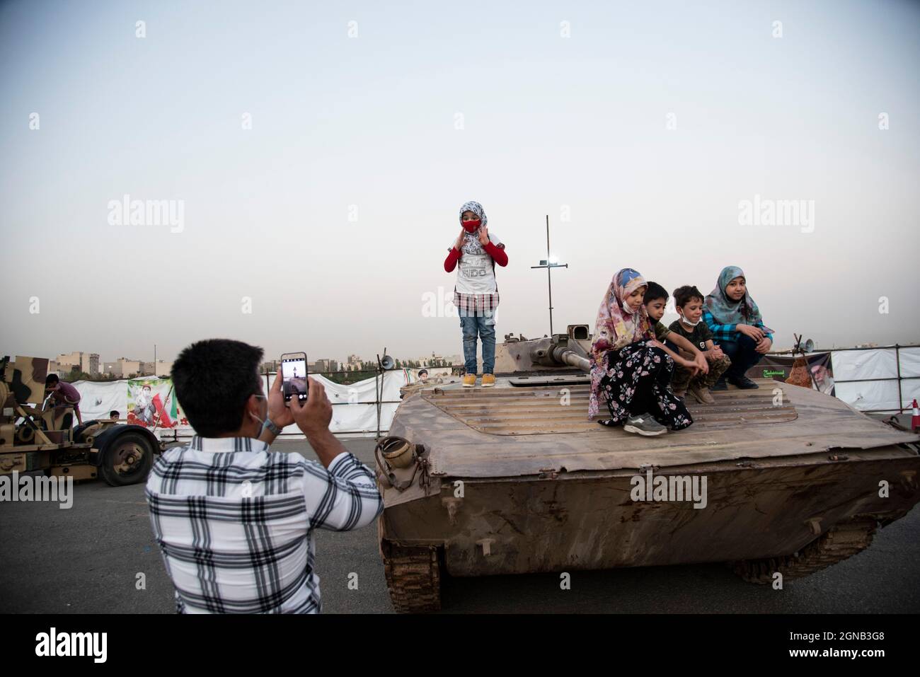 Teheran, Iran. 23 settembre 2021. Ragazzi e ragazze si posano con un carro armato militare mentre visitano una mostra di guerra che è tenuta e organizzata dal corpo di Guardia rivoluzionaria Islamica (IRGC) in un parco nel sud di Teheran per celebrare l'anniversario della guerra Iran-Iraq (1980-88) il 23 settembre 2021. (Foto di Sobhan Farajvan/Pacific Press) Credit: Pacific Press Media Production Corp./Alamy Live News Foto Stock