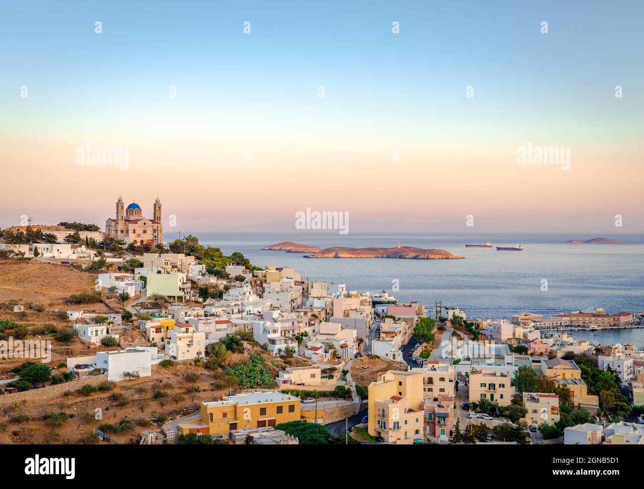 Tramonto panoramico a Ermoupolis, la capitale delle Cicladi, Grecia, con la chiesa di San Nicola sulla sinistra e il Mar Egeo sullo sfondo. Foto t Foto Stock
