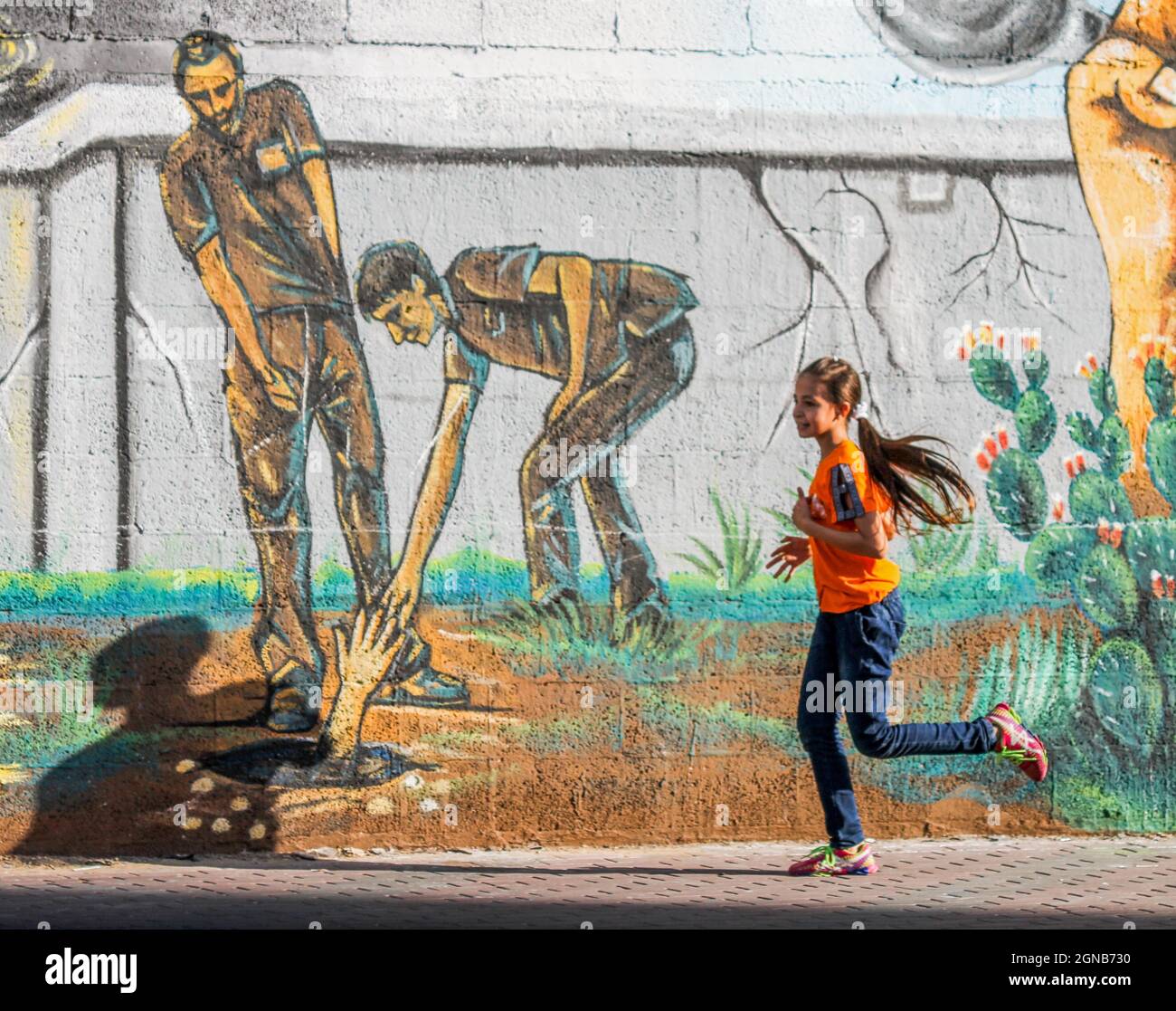 Città di Gaza, striscia di Gaza, Palestina. 23 settembre 2021. Gaza, Palestina. 23 settembre 2021. I palestinesi camminano vicino a un murale raffigurante i 6 prigionieri palestinesi fuggiti dalla prigione di Gilboa il 6 settembre 2021. Anche se Israele ha catturato tutti e sei i prigionieri palestinesi fuggiti dalla prigione di massima sicurezza israeliana, i palestinesi hanno salutato i fuggitivi come eroi nella loro lotta contro l'occupazione israeliana (immagine di credito: © Ahmad Hasaballah/IMAGESLIVE via ZUMA Press Wire) Foto Stock