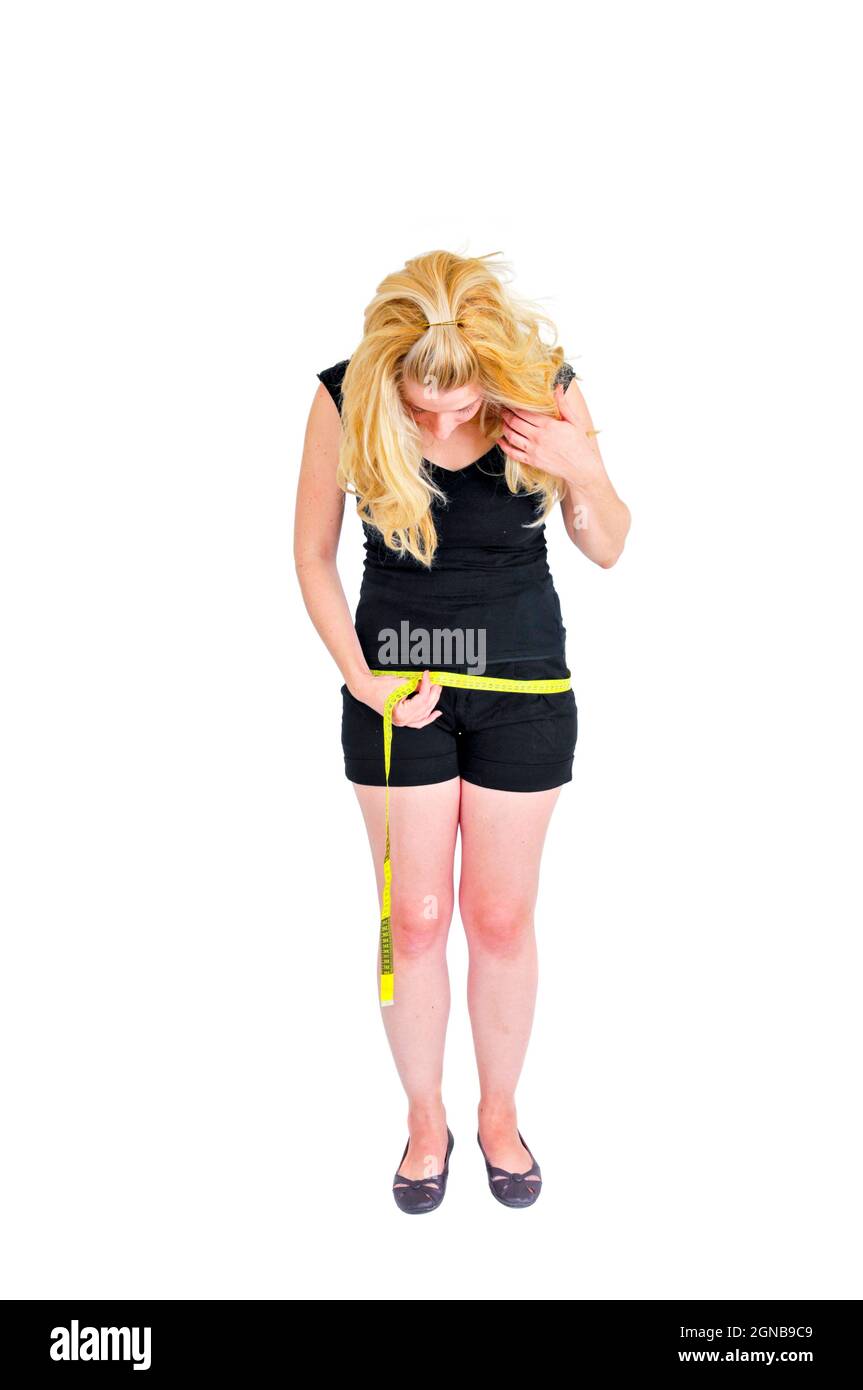 Immagine del corpo - la giovane donna misura la sua anca Foto Stock