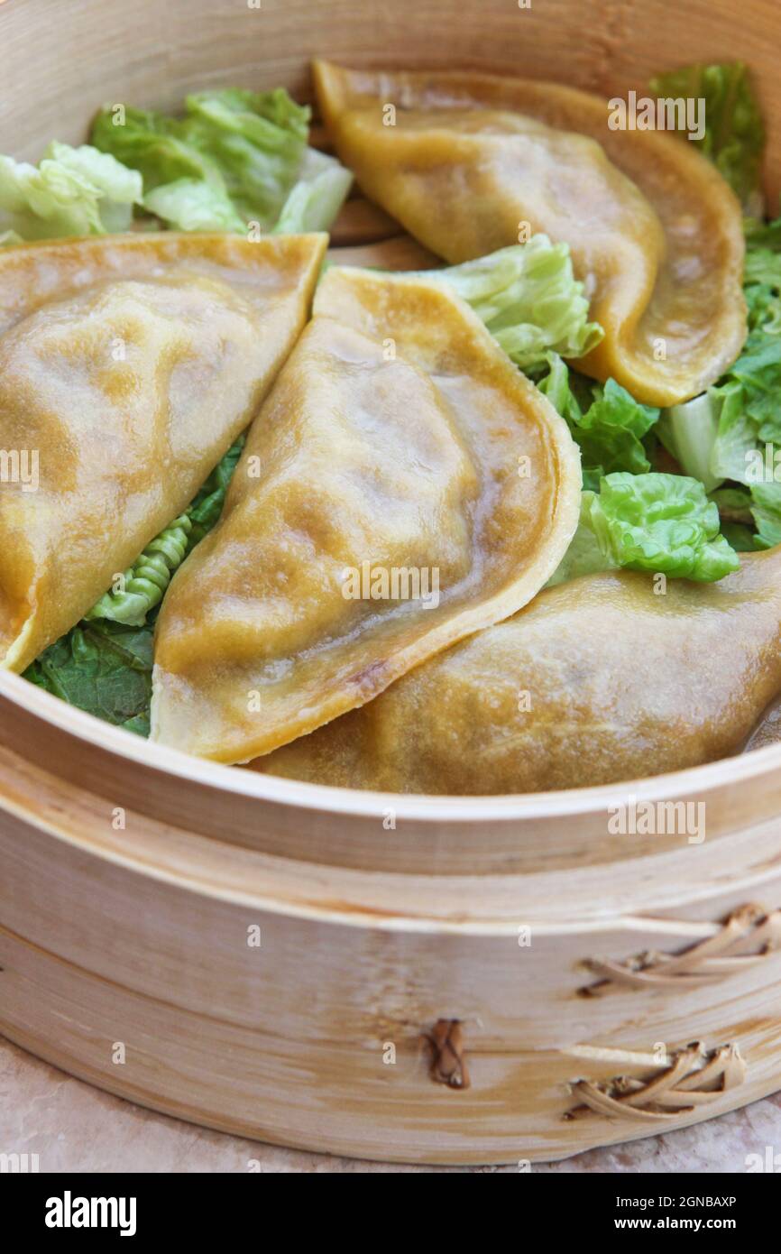 Streaming gyoza (Jiaozi) in bamboo cestello per la cottura a vapore Foto Stock