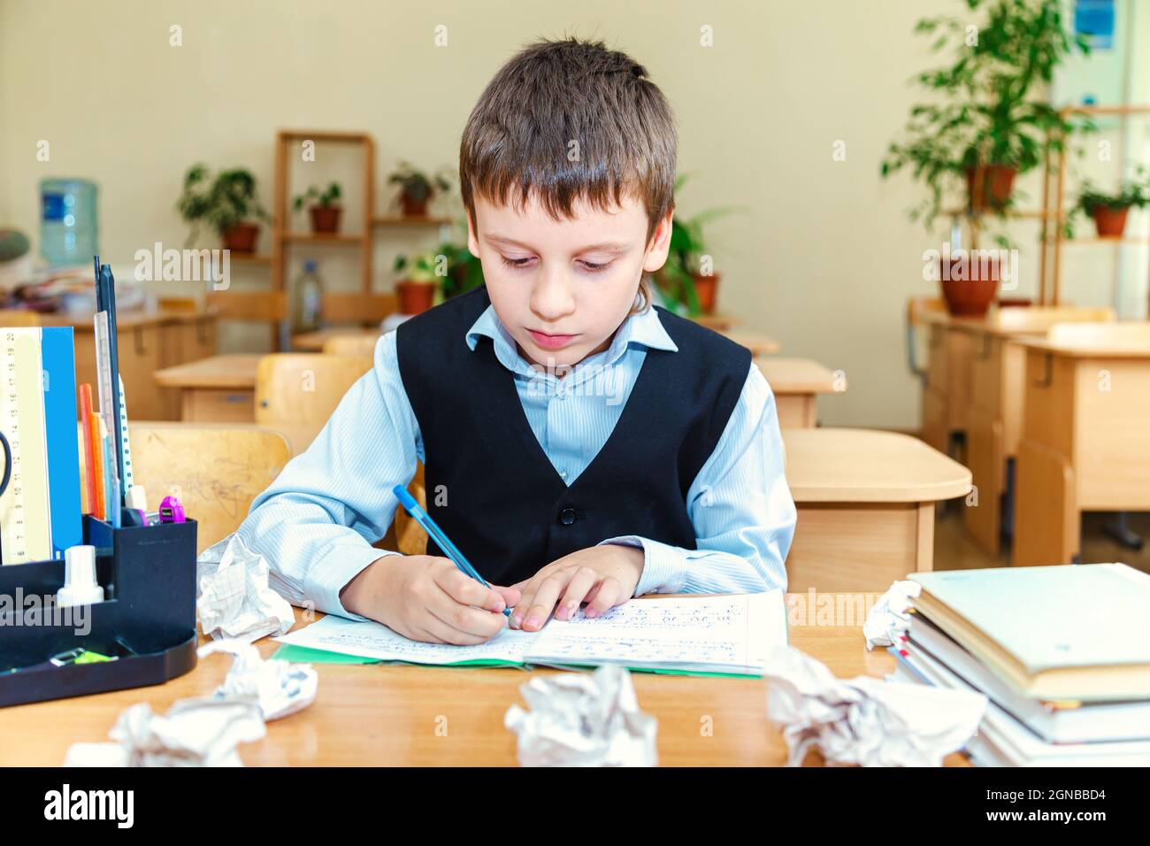 Scolaro serio in classe. Studente della scuola elementare. Ritorno a scuola. Foto Stock