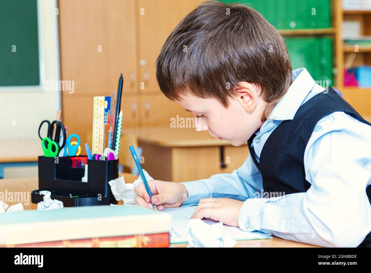 Scolaro serio in classe. Studente della scuola elementare. Ritorno a scuola. Foto Stock