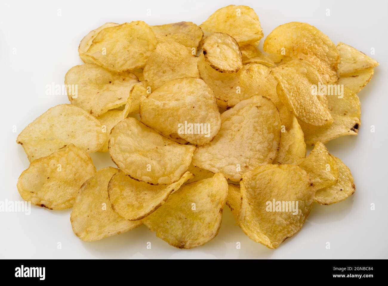 Mucchio di patatine organiche su sfondo bianco, sottili fette di bio-patata con la buccia fritta Foto Stock
