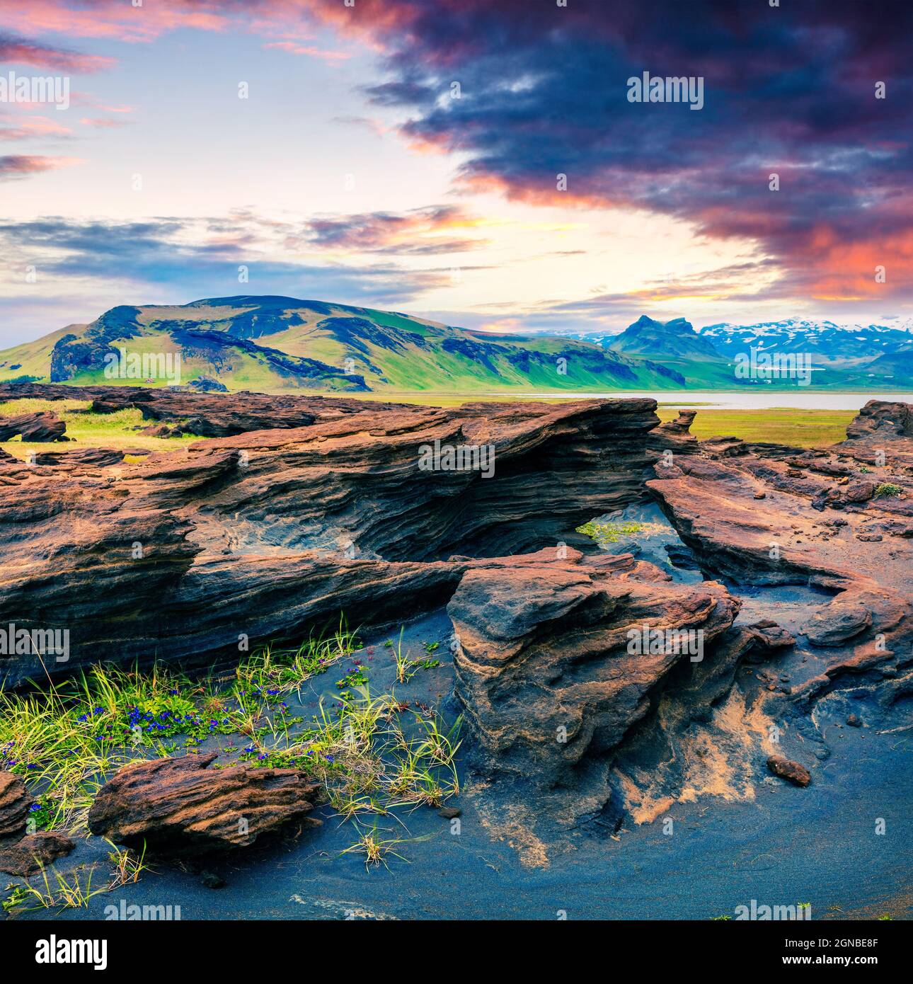 Tipico paesaggio islandese sulla costa meridionale dell'Islanda. Colorata alba estiva con terreno vulcanico. Foto elaborata in stile artistico. Foto Stock