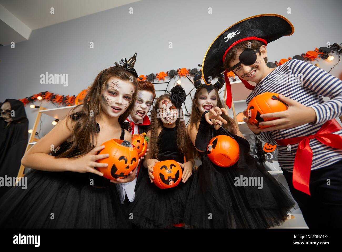 I bambini travestiti come vari caratteri spooky desiderano i trucchi o le delizie al partito di Halloween. Foto Stock