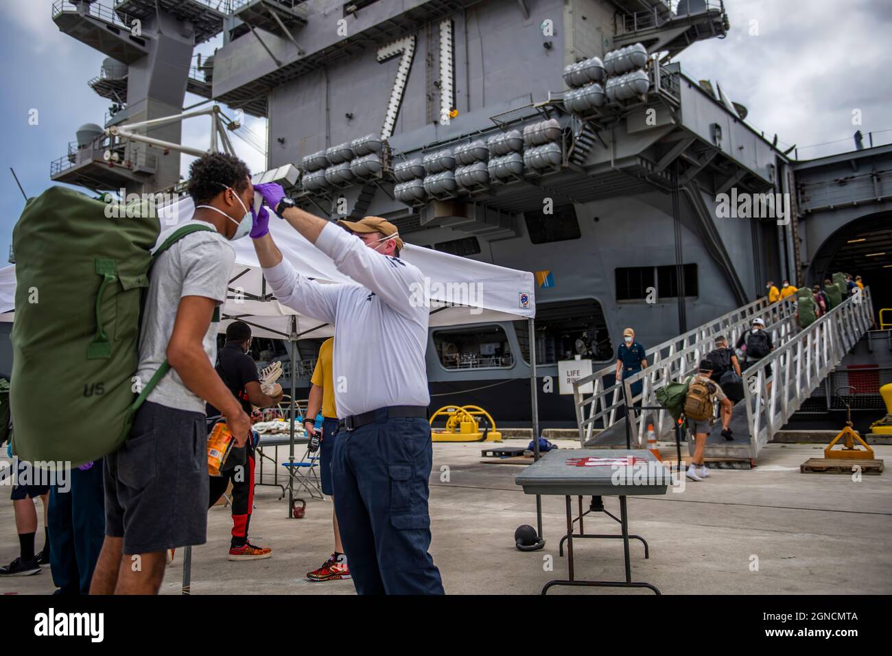 APRA HARBOUR, Guam (1 maggio 2020) i marinai assegnati alla portaerei USS Theodore Roosevelt (CVN 71), che hanno provato negativo due volte per COVID-19, sono asintomatici e hanno completato la loro quarantena off-ship o isolamento, si preparano a salire a bordo della nave pulita. Migliaia di marinai di Theodore Roosevelt sono stati spostati negli hotel locali nel tentativo di implementare una strategia di mitigazione aggressiva per ridurre al minimo la diffusione di COVID-19 e proteggere la salute dei marinai. (STATI UNITI Foto Navy di Mass Communication Specialist 1a Classe Nathan Carpenter/Released)200501-N-CO914-1022 Foto Stock