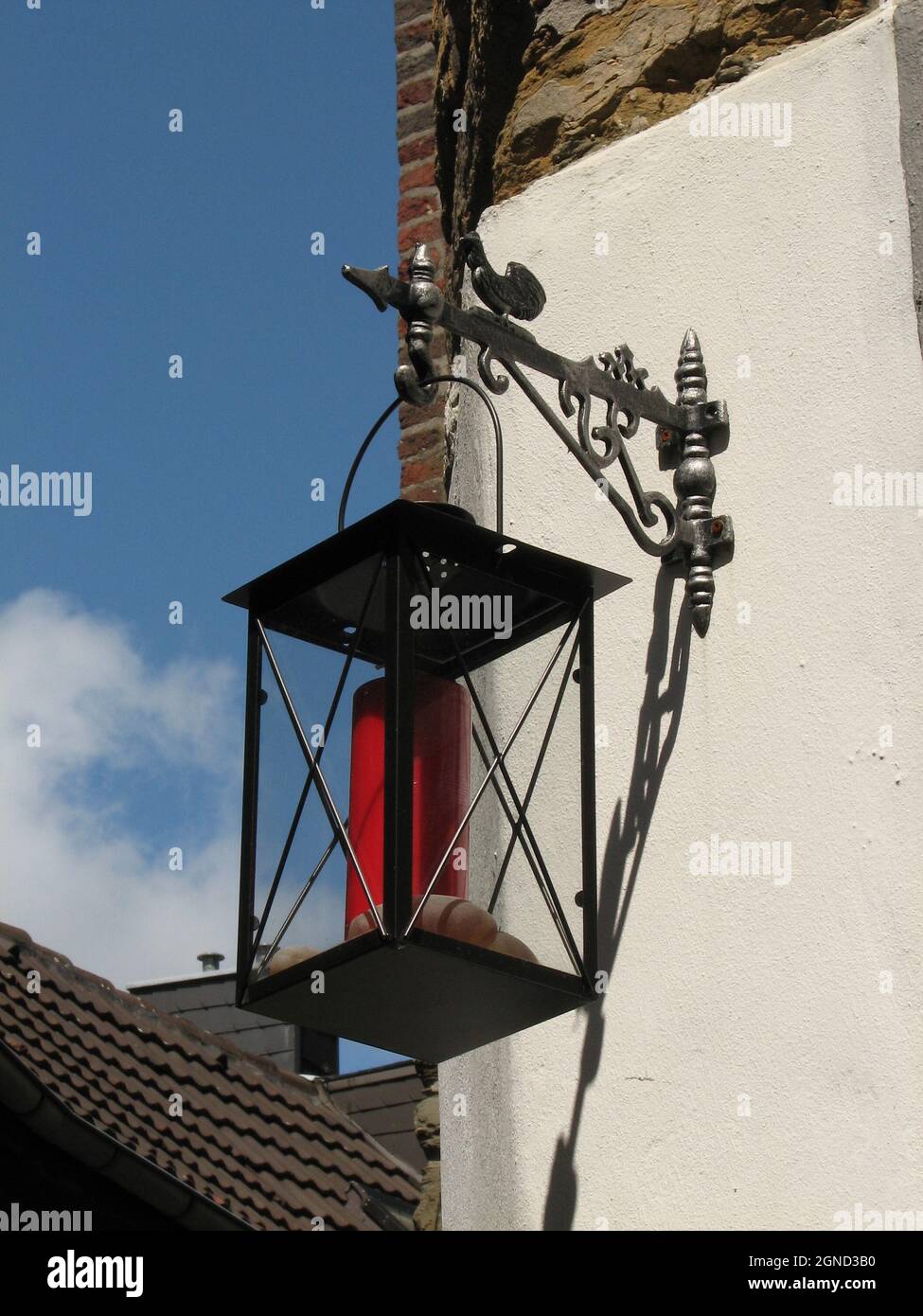 Vista di una lanterna appesa al palo sul muro della strada Foto Stock