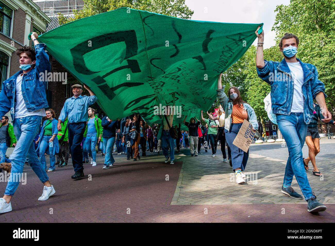 I manifestanti hanno una grande bandiera verde durante la dimostrazione.questo venerdì, decine di migliaia di bambini in più di 60 paesi sono andati in sciopero per chiedere l'azione per il cambiamento climatico. #FridaysForFuture è un movimento iniziato nell'agosto 2018, dopo che Greta Thunberg, 15 anni, si è seduto di fronte al parlamento svedese ogni giorno scolastico per tre settimane, per protestare contro la mancanza di azione sulla crisi climatica. A Utrecht, non solo gli studenti, ma gli insegnanti, gli attivisti climatici, provenienti da tutto il paese hanno protestato per una migliore politica climatica e per fermare la distruzione delle terre di MAPA (popoli più colpiti) Foto Stock