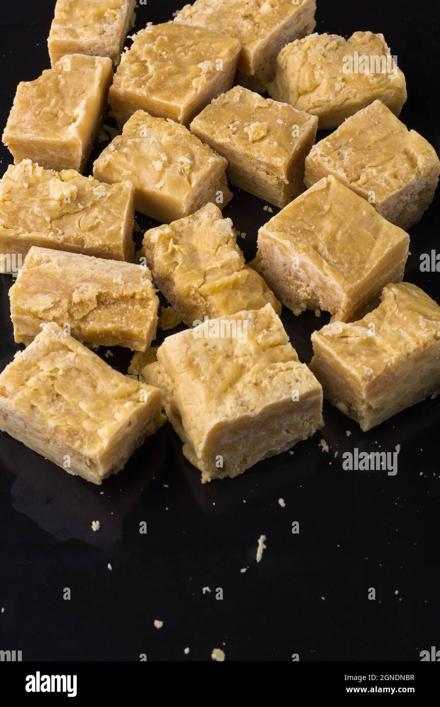 toffee al latte di patate o fudge di patate, caramelle dolci su una superficie riflettente nera Foto Stock
