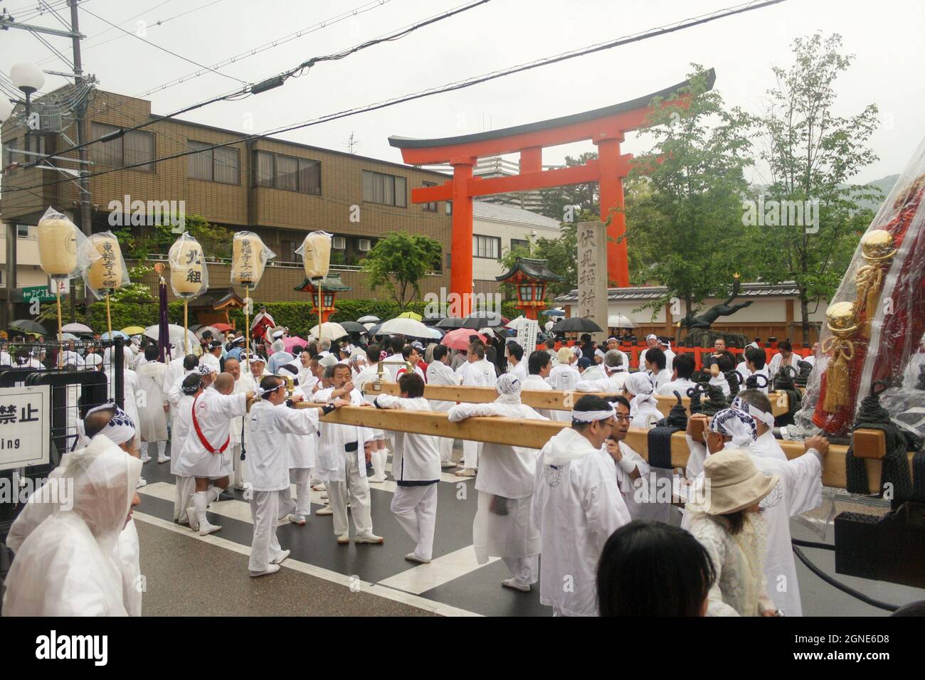 La folla di persone che indossano un costume bianco si radunano presso la grande porta Torii rossa del Santuario Fushimi Inari durante l'evento del festival. Foto Stock