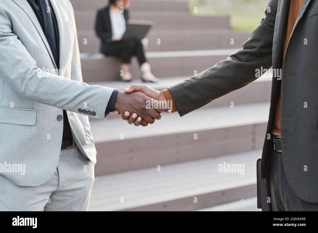 Sezione orizzontale media ripresa di irriconoscibili afroamericani uomini che indossano abiti eleganti che si salutano a vicenda con una stretta di mano Foto Stock