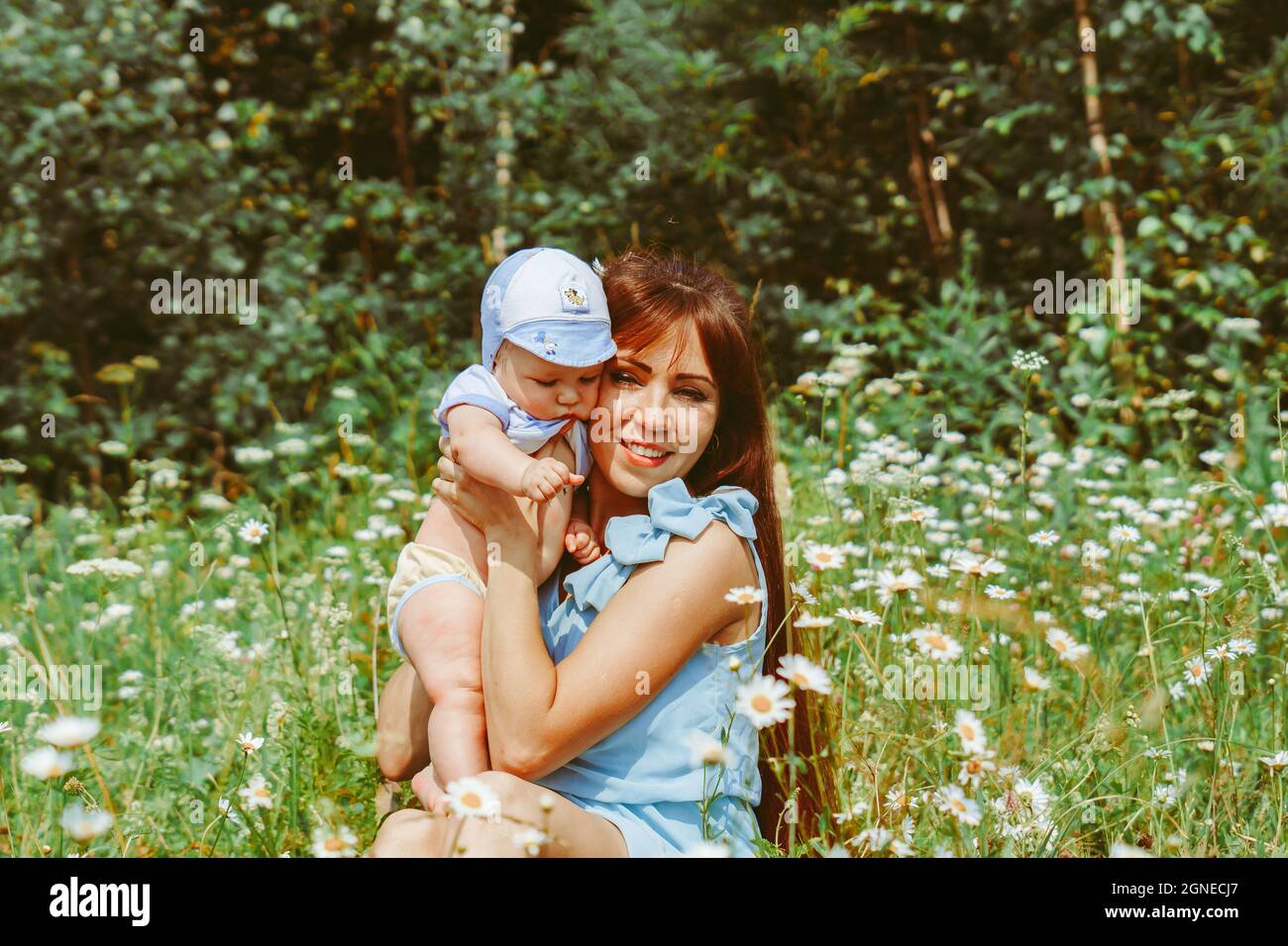 la madre alza il bambino tra le braccia Foto Stock